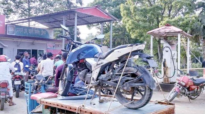 দীর্ঘ লাইনে ভ্যানে মোটরসাইকেল - তেলের জন্য অভিনব উদ্যোগ